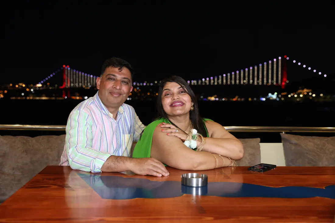 Couple on a yacht at night with the Bosphorus Bridge