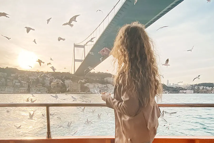 Girl watching seagulls under the Bosphorus Bridge