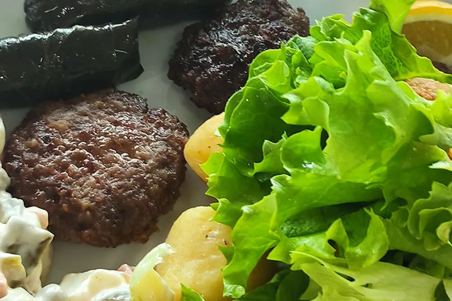 Grilled meatballs, salad and mezes served for lunch on board