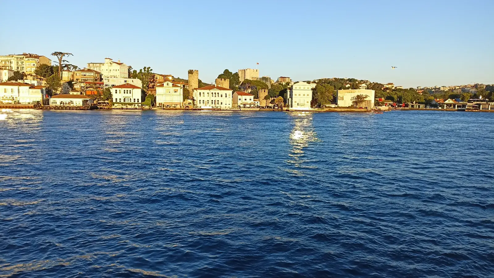 Yacht cruising past waterfront mansions on the Bosphorus