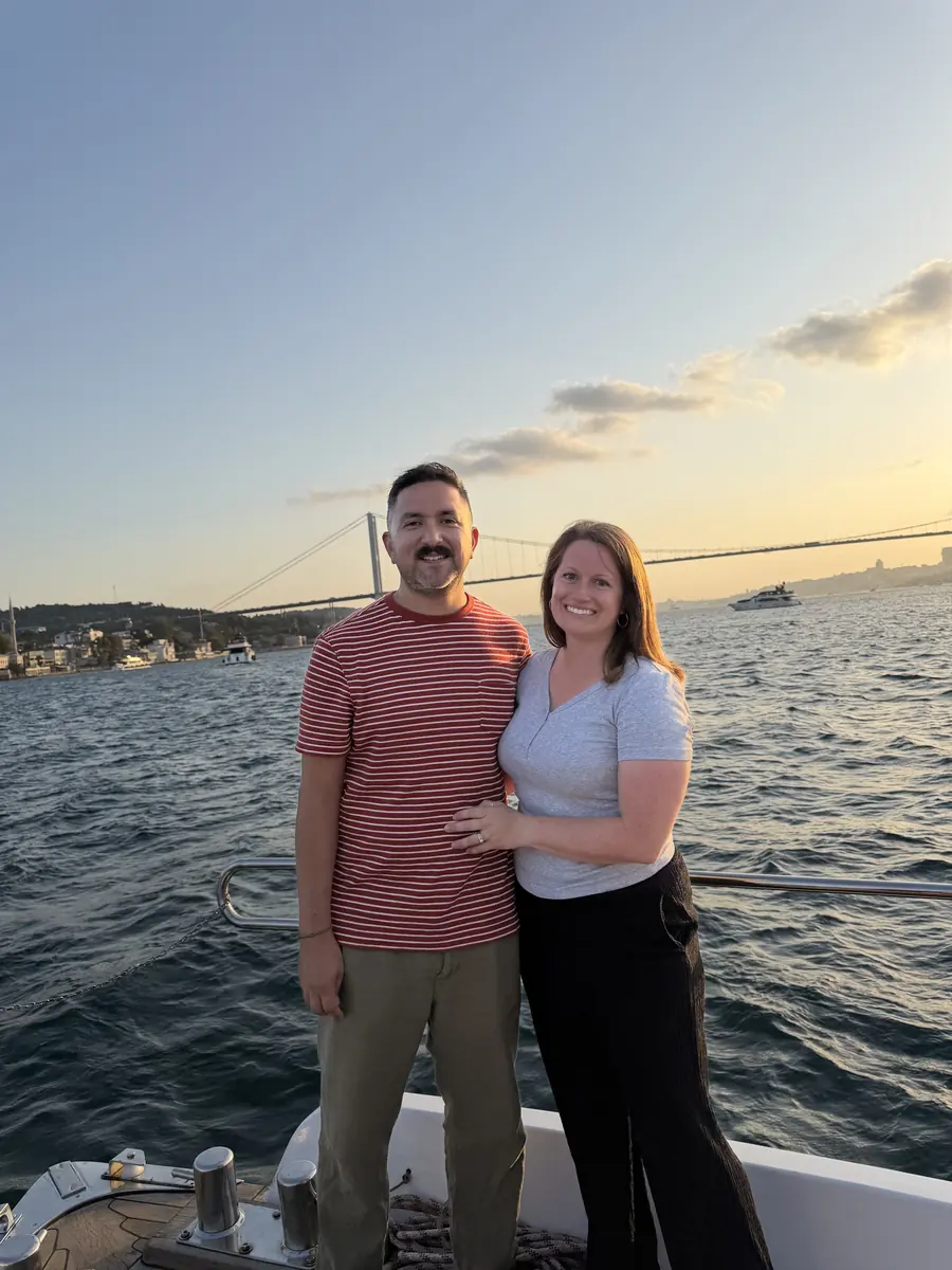 Couple on the sunset cruise with the Bosphorus Bridge in soft evening light