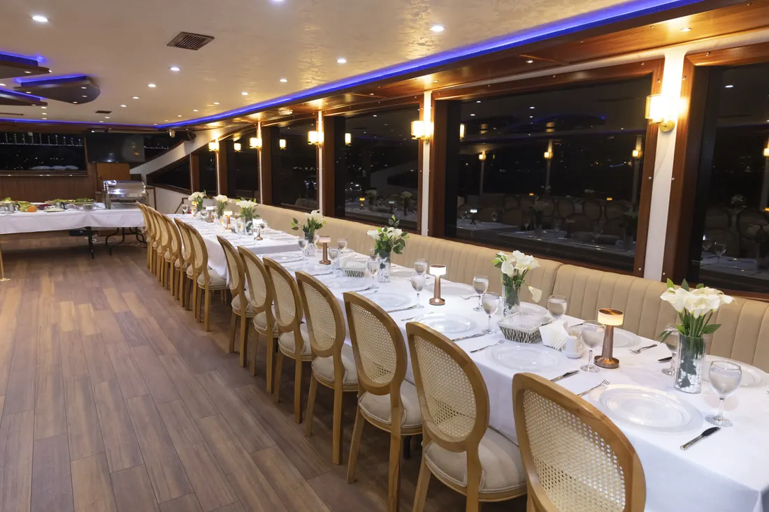 Yacht saloon set with long tables for a gala dinner