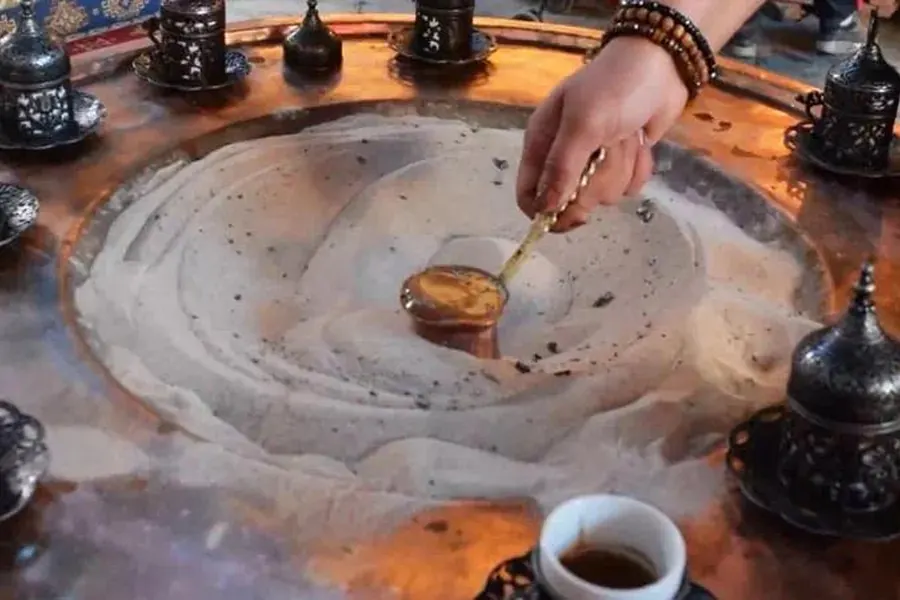 Turkish coffee being cooked in hot sand