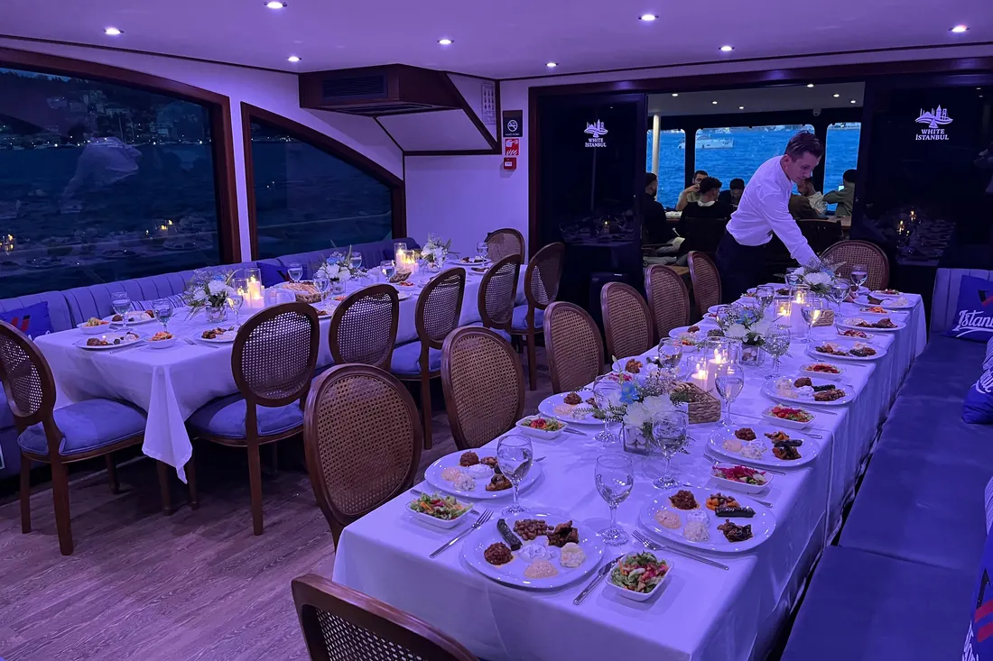 Long dinner table set in the saloon of a private yacht in Istanbul