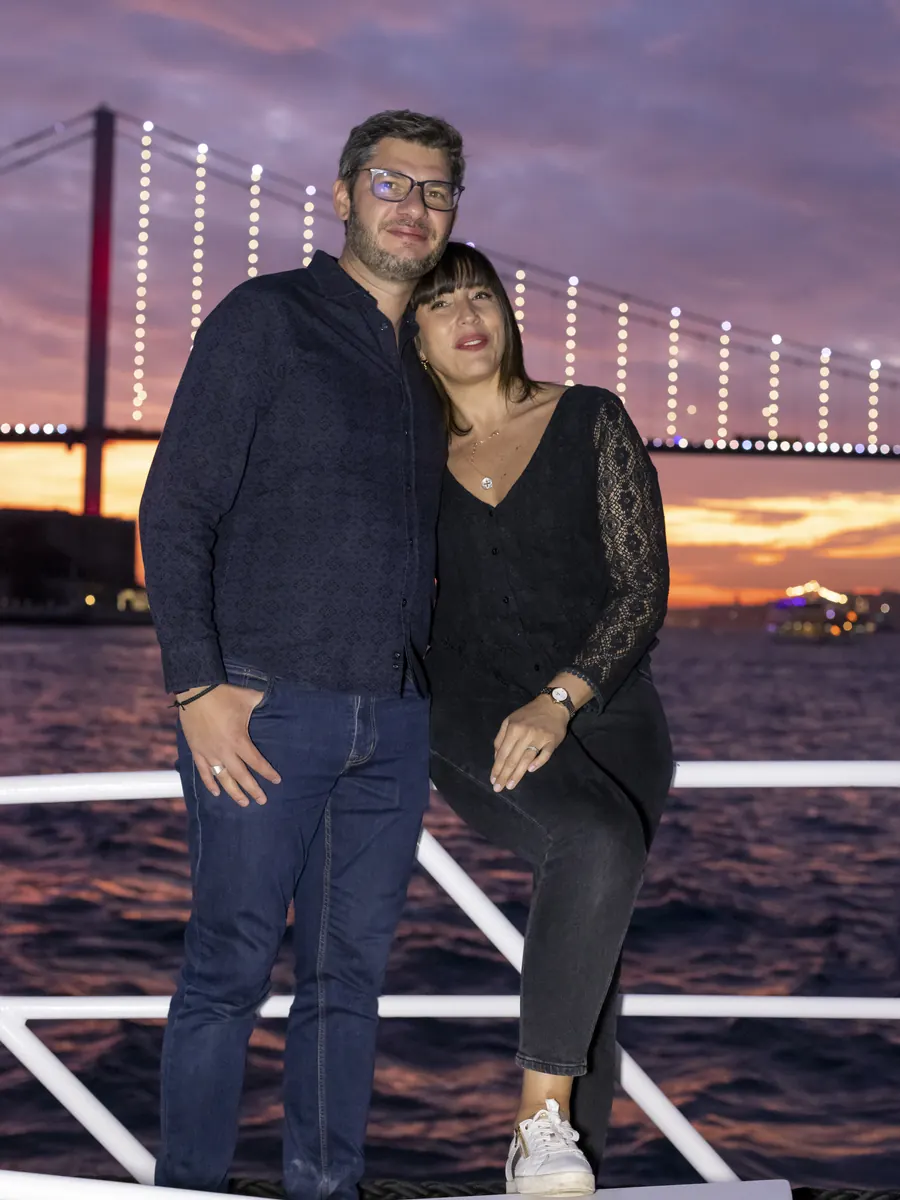 Couple on a yacht with the illuminated Bosphorus Bridge