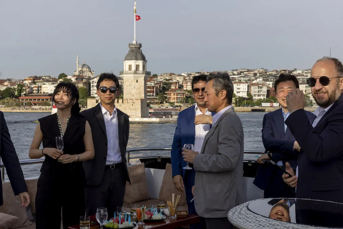Guests at a launch event on a yacht in front of the Maiden's Tower