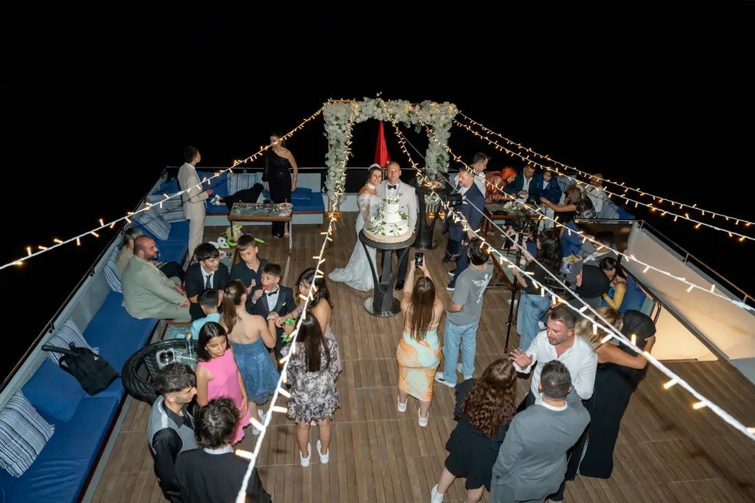 Wedding reception guests on a yacht deck at night
