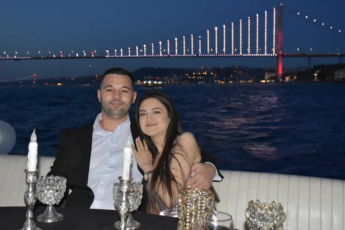 Couple at an anniversary dinner with the Bosphorus Bridge lit up