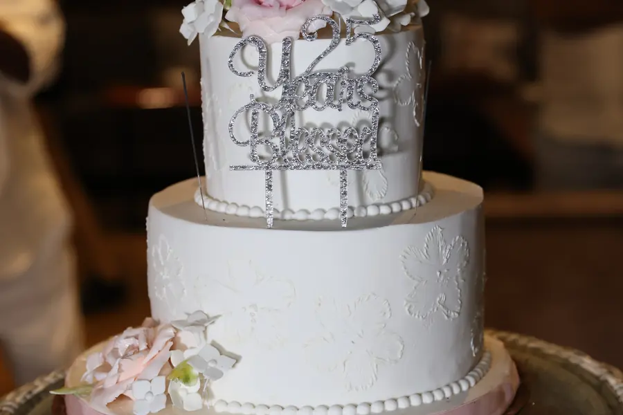 Tiered celebration cake decorated with flowers on a yacht