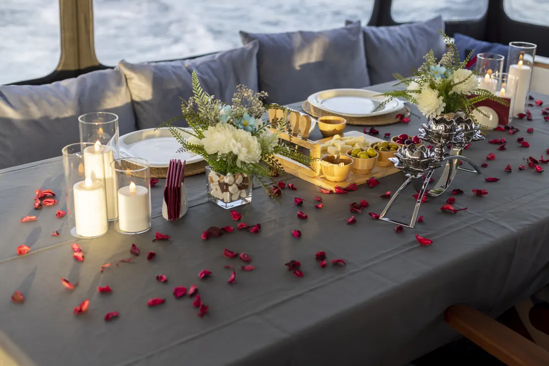 Romantic table with candles and rose petals on a yacht