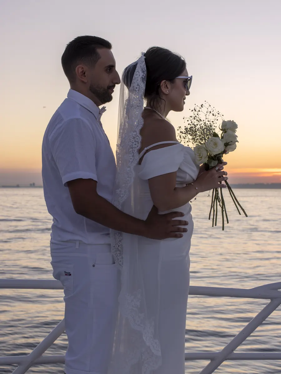 Bride and groom embracing on a yacht at sunset
