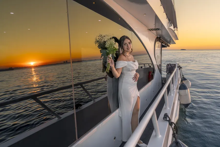 Bride with her bouquet on a yacht at sunset