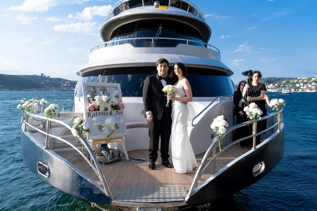 Couple on the bow of a yacht decorated with wedding flowers